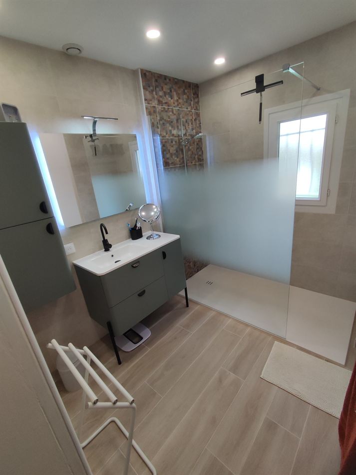 Salle de bains rénovée avec douche de plain-pied, paroi vitrée et meuble suspendu