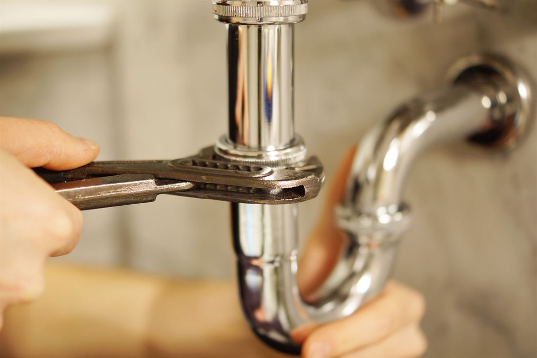 Serrage d'un siphon de lavabo à la clé